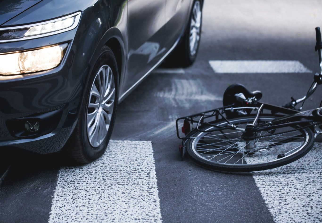 car beside a bicycle laying on the road