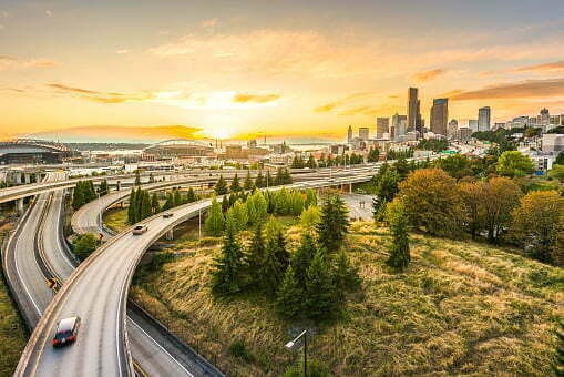 Seattle skylines and Interstate freeways converge with Elliott Bay and the waterfront background of in sunset time, Seattle, Washington State, USA.
