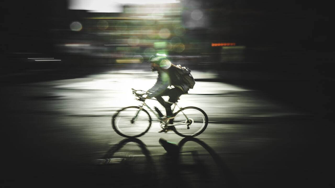 man wearing back pack riding on a bicycle