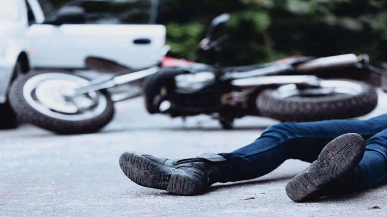 Man Victim of a Motorcycle Accident Lying on the Road Unconscious