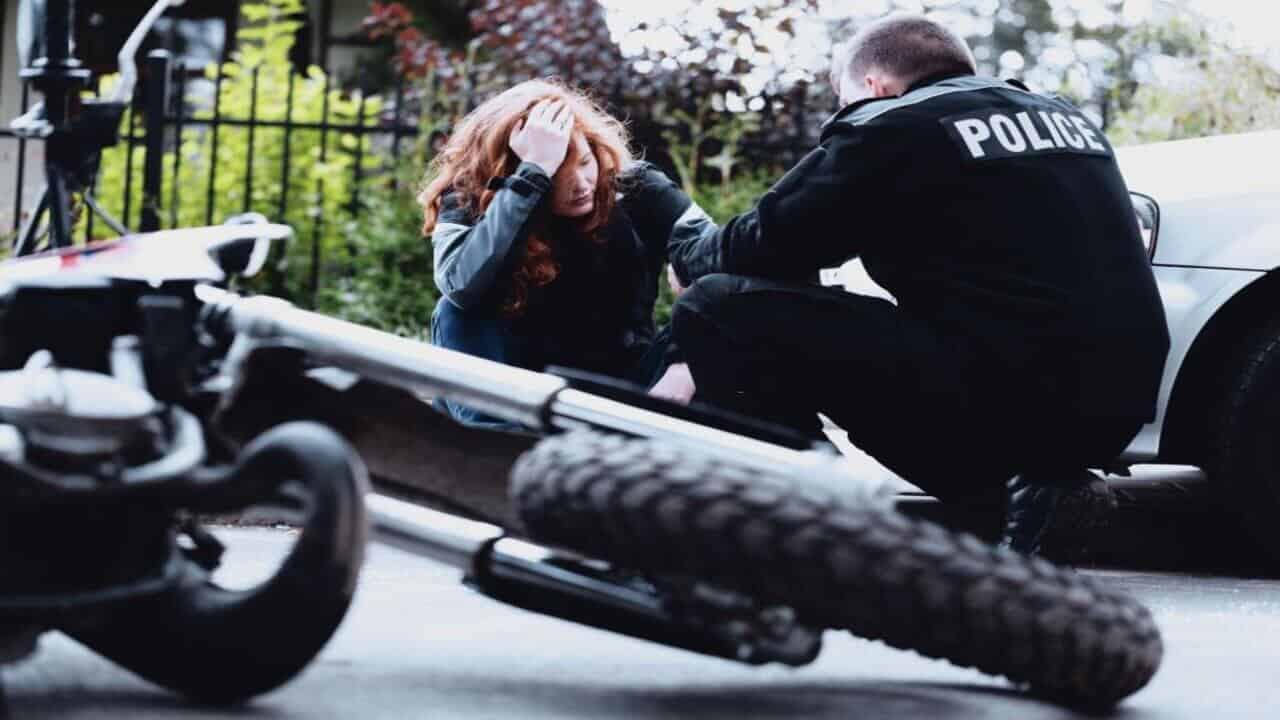 Policeman Interviewing a Woman Driver of a Black Motorbike After an Accident