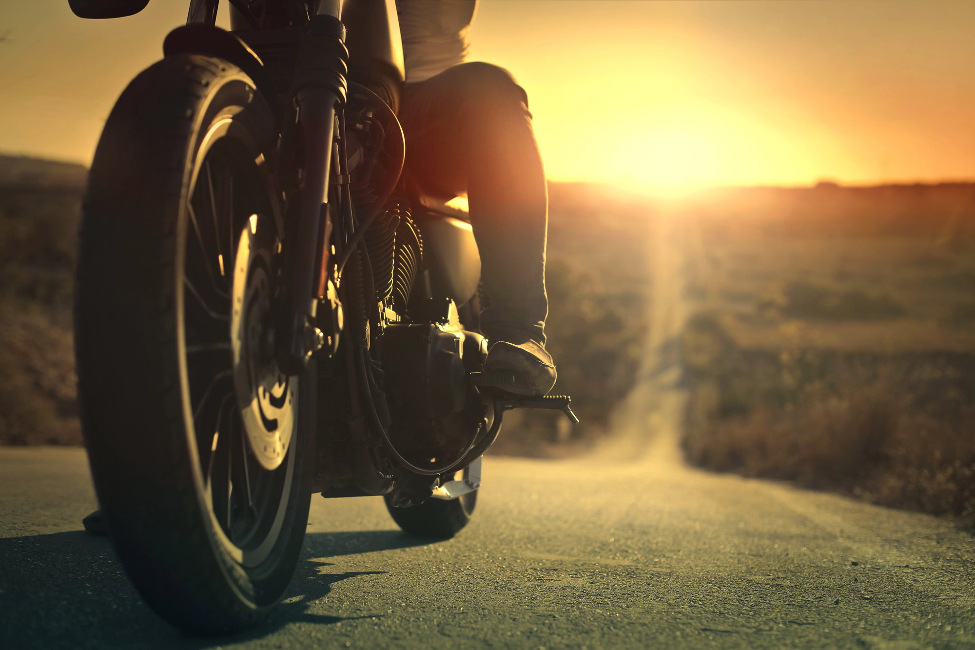 A motorcycle on the road with a sunset in the background; a motorcycle license is required in Washington for most two-wheeled motorbikes