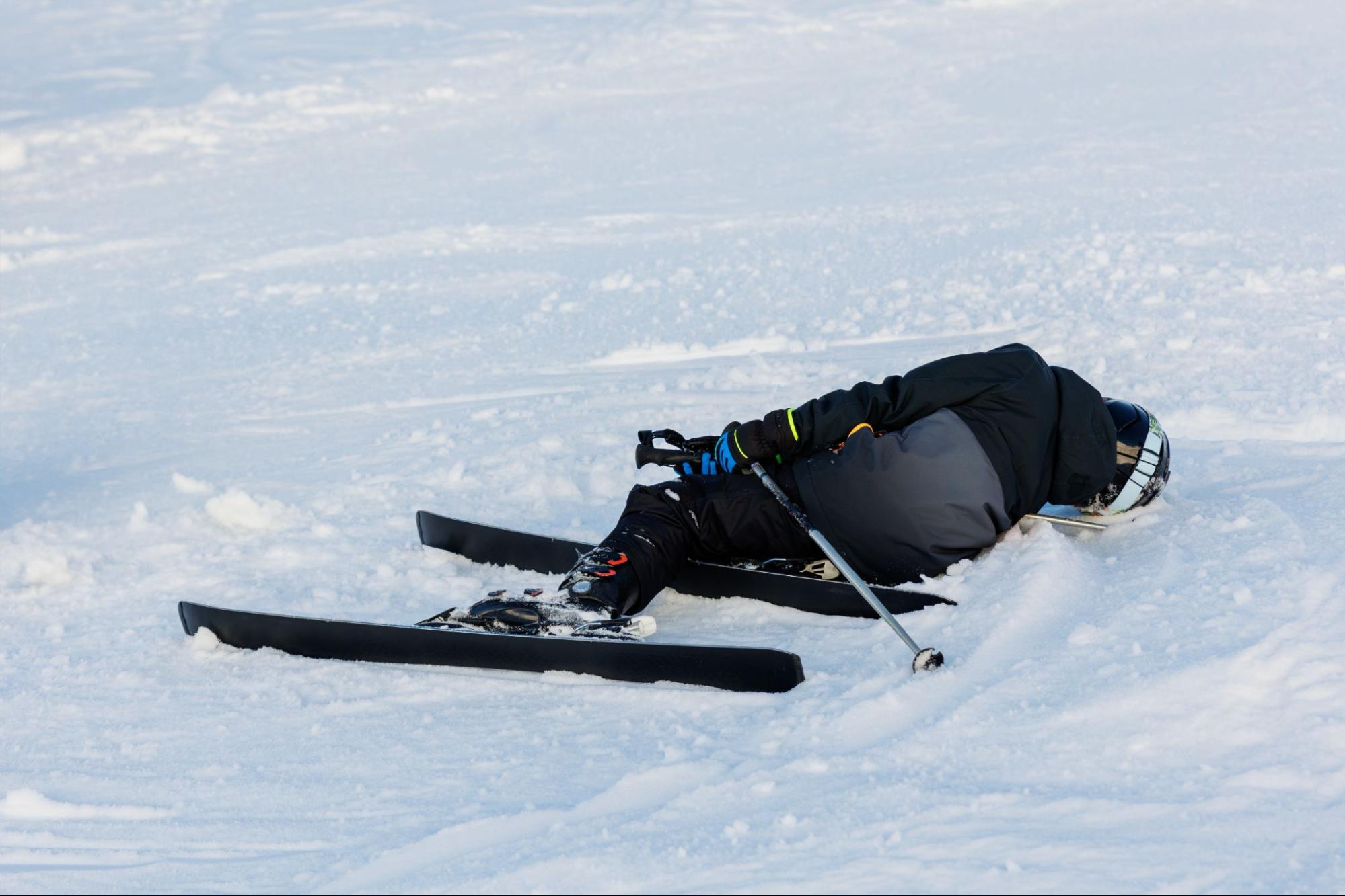 An injured skiier lays down thinking about a product liability lawsuit after falling due to faulty ski equipment.